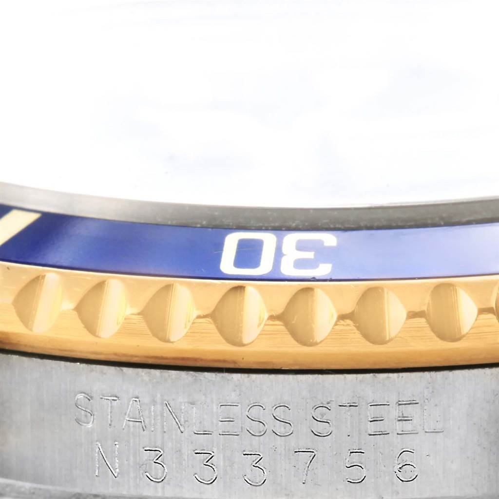 The image shows a close-up of the bezel, crown, and engraved serial number on a Rolex Submariner 16613 Men's Steel and Gold (two tone) Blue Dial 16613 Men's Steel and Gold (two tone) Blue Dial watch.