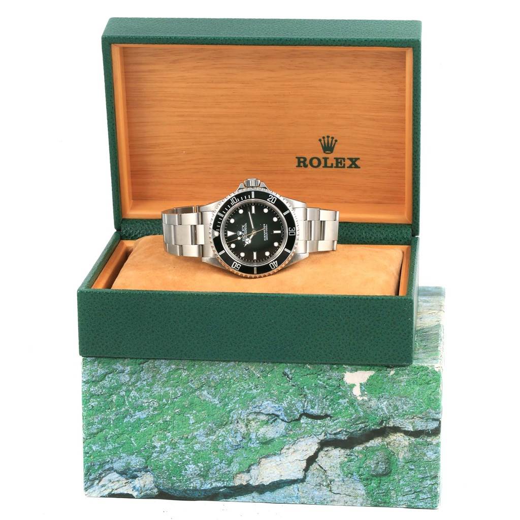 The image shows a Rolex Submariner 14060 Men's Stainless Steel Black Dial 14060 Men's Stainless Steel Black Dial watch displayed in an open green and wooden Rolex box from a front angle.
