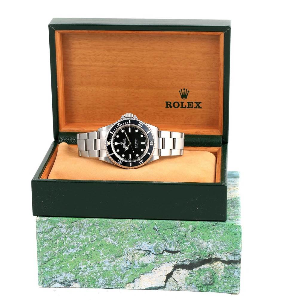 This image shows a Rolex Submariner 14060 Men's Stainless Steel Black Dial 14060 Men's Stainless Steel Black Dial watch displayed at a front angle in its original green and wood-colored box.