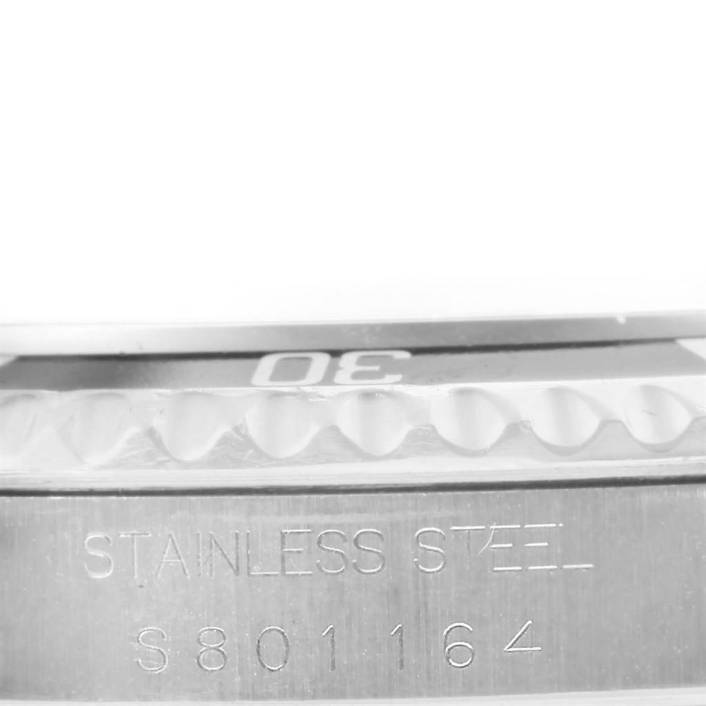 This image shows a macro view of the bezel and case side of a Rolex Submariner 14060 Men's Stainless Steel Black Dial 14060 Men's Stainless Steel Black Dial watch, highlighting its stainless steel construction and partial serial number.