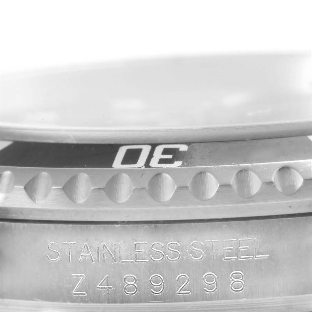 A close-up view of the bezel and case of a Rolex Submariner 16610 Men's Stainless Steel Black Dial 16610 Men's Stainless Steel Black Dial watch with visible engraved model details.