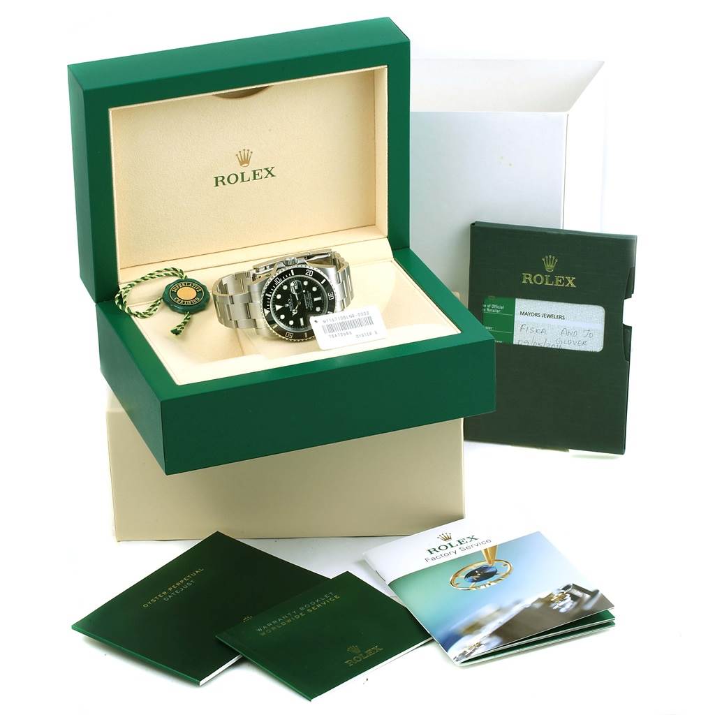 The image shows a Rolex Submariner 116610 Men's Stainless Steel Black Dial 116610 Men's Stainless Steel Black Dial watch and its accessories, including the box, manuals, and tags, viewed from an elevated angle.