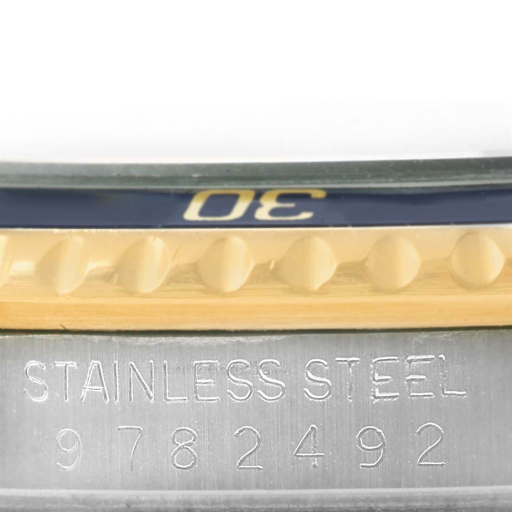 This close-up shows a segment of the bezel and case with serial number of a Rolex Submariner 16803 Men's Steel and Gold (two tone) Blue Dial 16803 Men's Steel and Gold (two tone) Blue Dial watch.