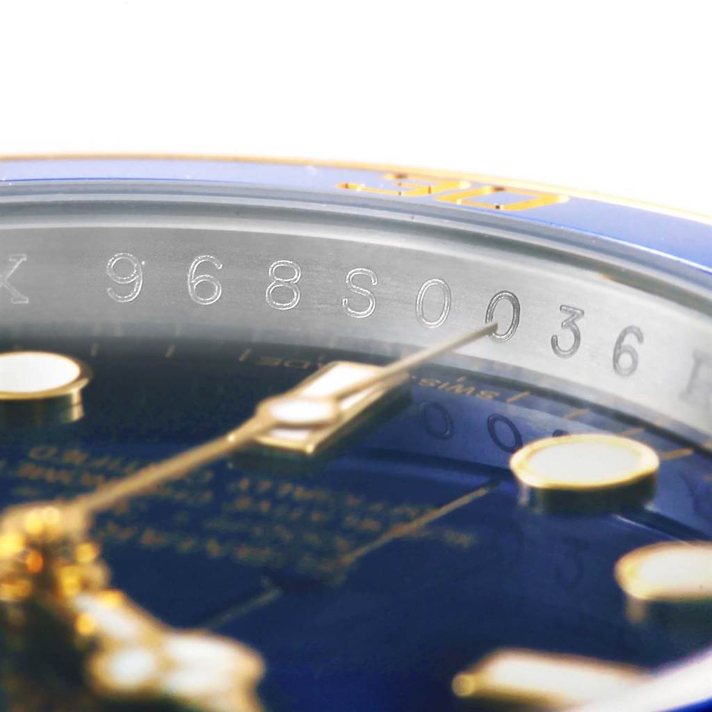 The image shows a close-up of the serial number and part of the dial of a Rolex Submariner 116613 Men's Steel and Gold (two tone) Blue Dial 116613 Men's Steel and Gold (two tone) Blue Dial watch.