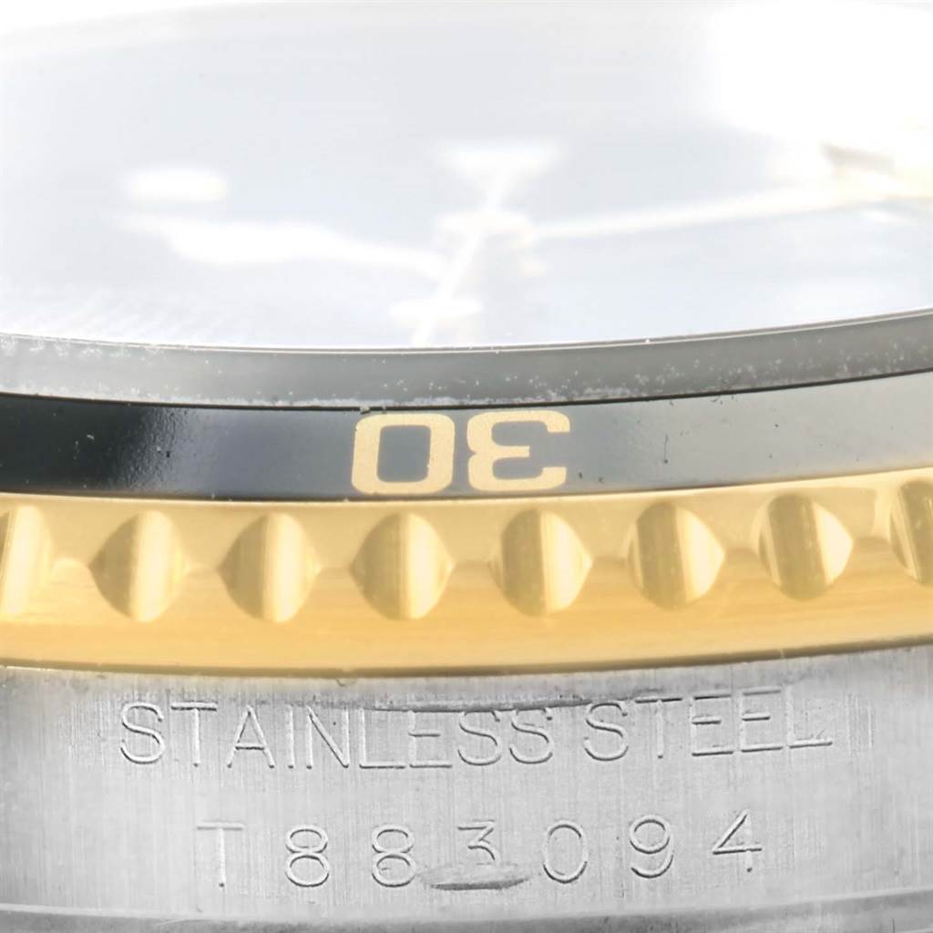 The image shows a close-up of the bezel and part of the case, including the serial number of a Rolex Submariner 16613 Men
s Steel and Gold (two tone) Black Dial 16613 Men
s Steel and Gold (two tone) Black Dial watch.