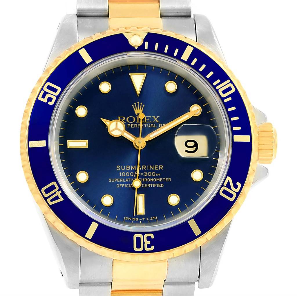 The image shows a Rolex Submariner 16613 Men's Steel and Gold (two tone) Blue Dial 16613 Men's Steel and Gold (two tone) Blue Dial watch face with a blue dial, golden accents, and the date aperture at the 3 o'clock position.