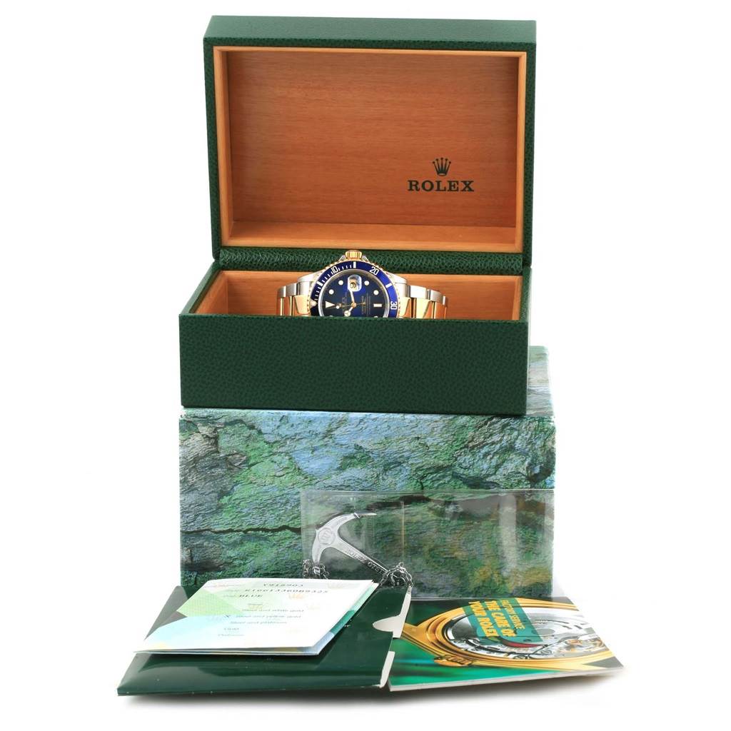 The Rolex Submariner 16613 Steel and Gold (two tone) Blue Dial 16613 Steel and Gold (two tone) Blue Dial is shown in its box with paperwork and accessories beneath it, viewed from the front at a slight downward angle.
