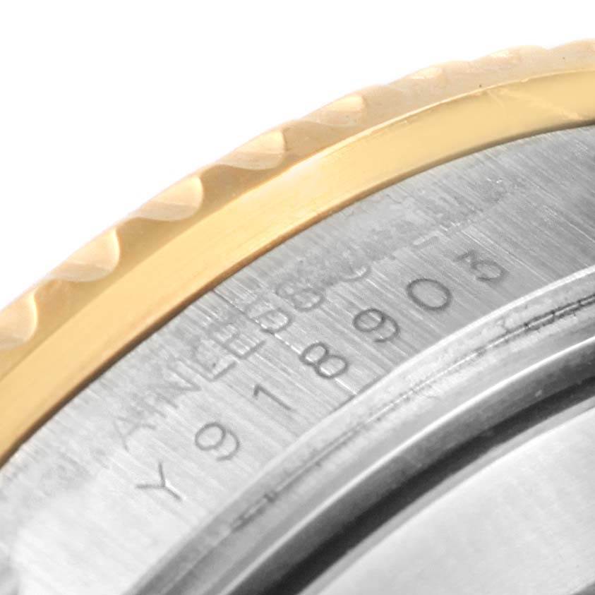This is a close-up of the side of the bezel and case of a Rolex Submariner 16613 Steel and Gold (two tone) Blue Dial 16613 Steel and Gold (two tone) Blue Dial watch, showing part of the serial number.