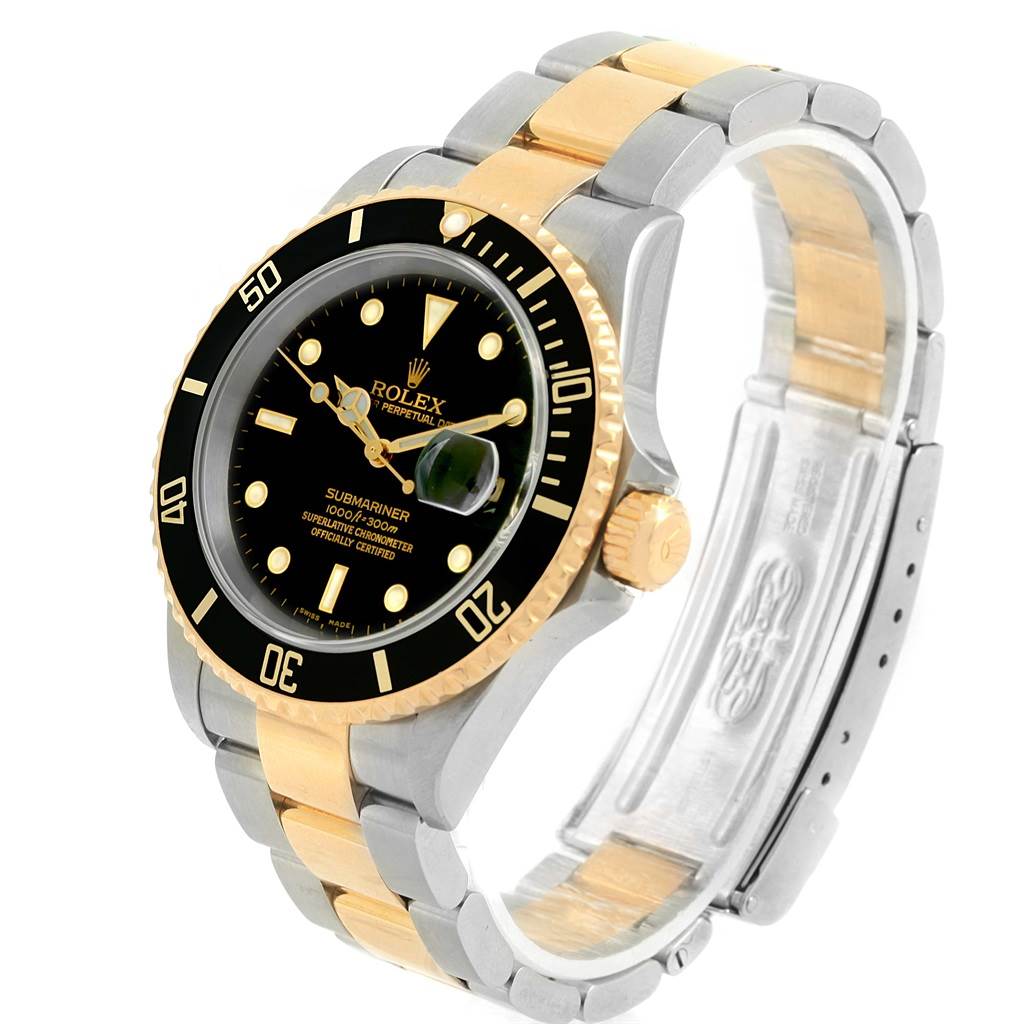 The image shows a Rolex Submariner 16613 Men
s Steel and Gold (two tone) Black Dial 16613 Men
s Steel and Gold (two tone) Black Dial watch at a front-left angle, highlighting the black bezel, dial, and two-tone bracelet.