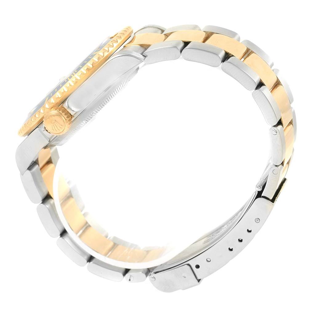 The image shows the side profile of a Rolex Submariner 16613 Men's Steel and Gold (two tone) Blue Dial 16613 Men's Steel and Gold (two tone) Blue Dial's case and two-tone (gold and steel) bracelet clasp.