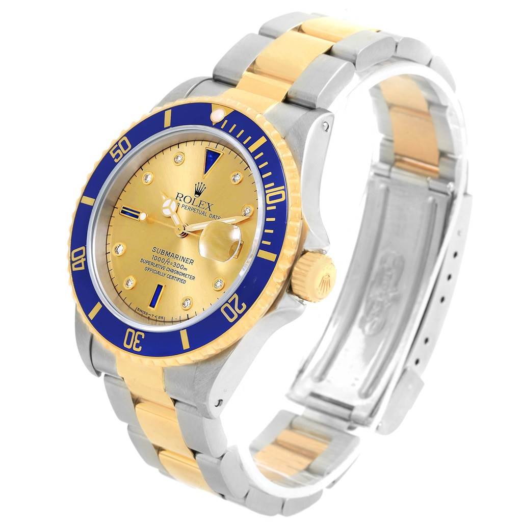 The image shows a Rolex Submariner 16613 Men
s Steel and Gold (two tone) Champagne Dial 16613 Men
s Steel and Gold (two tone) Champagne Dial watch at an angle displaying its face, bezel, crown, and partially open bracelet.