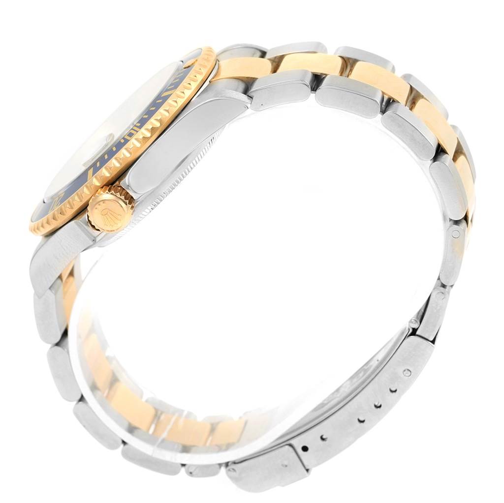 The image shows a side view of a Rolex Submariner 16613 Men's Steel and Gold (two tone) Blue Dial 16613 Men's Steel and Gold (two tone) Blue Dial watch, highlighting the crown, bezel, and two-tone metal bracelet.