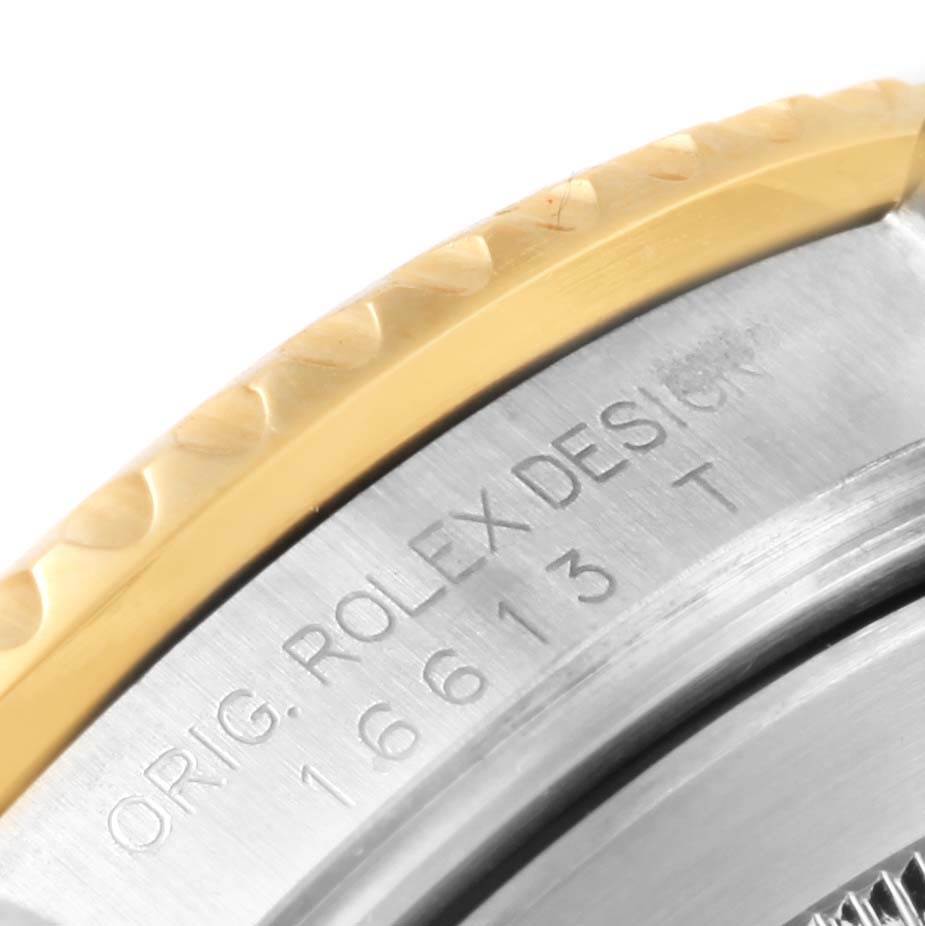 This close-up angle shows the engraved model number and the textured bezel of a Rolex Submariner 16613 Men's Steel and Gold (two tone) Blue Dial 16613 Men's Steel and Gold (two tone) Blue Dial watch.
