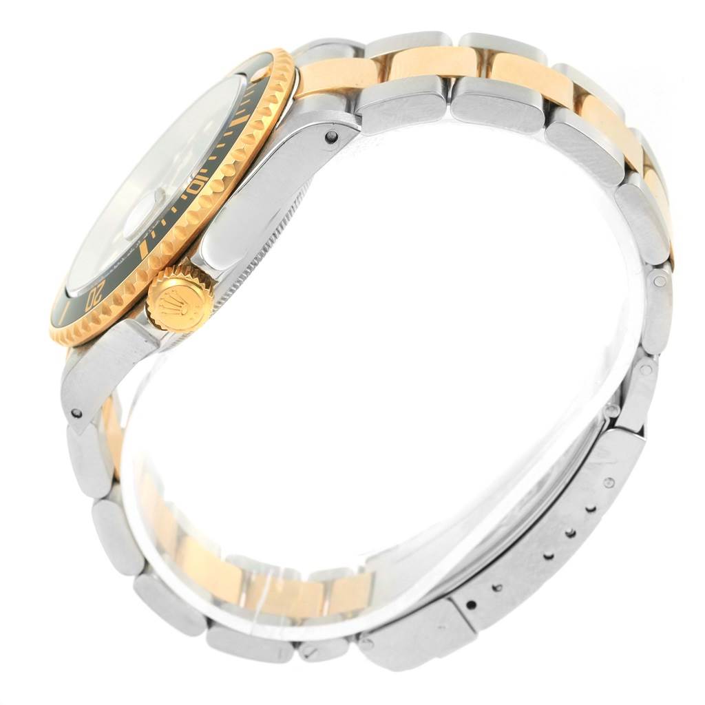 The image shows a side view of a Rolex Submariner 16613 Men's Steel and Gold (two tone) Black Dial 16613 Men's Steel and Gold (two tone) Black Dial watch, highlighting its crown, bezel, and two-tone metal bracelet.