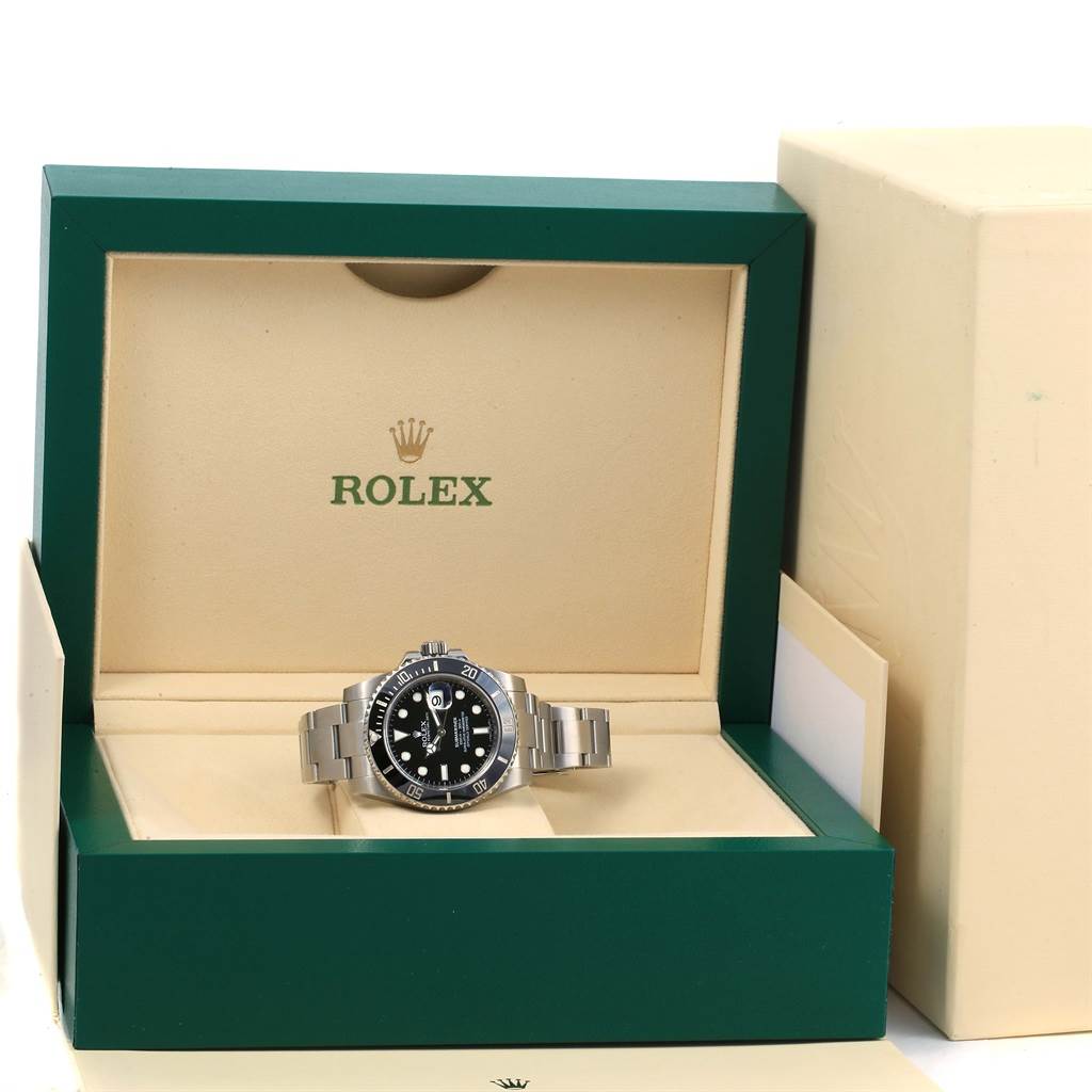 The Rolex Submariner 116610 Men's Stainless Steel Black Dial 116610 Men's Stainless Steel Black Dial watch is displayed frontally, presented in its branded green box with beige interior.