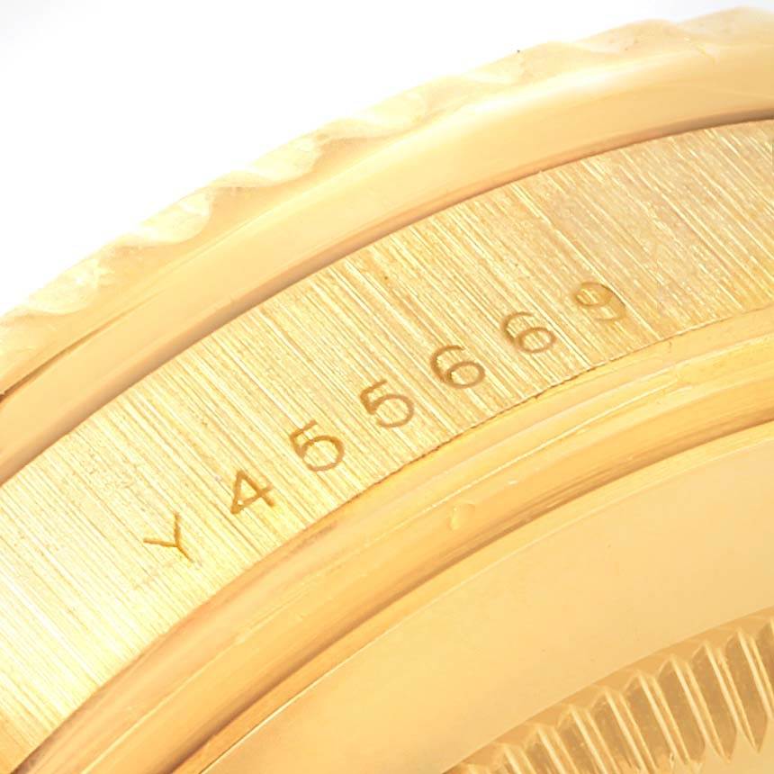 A close-up of the side of the Rolex Submariner 16618 Men's Yellow Gold Blue Dial 16618 Men's Yellow Gold Blue Dial model, focusing on the engraved serial number on the case.