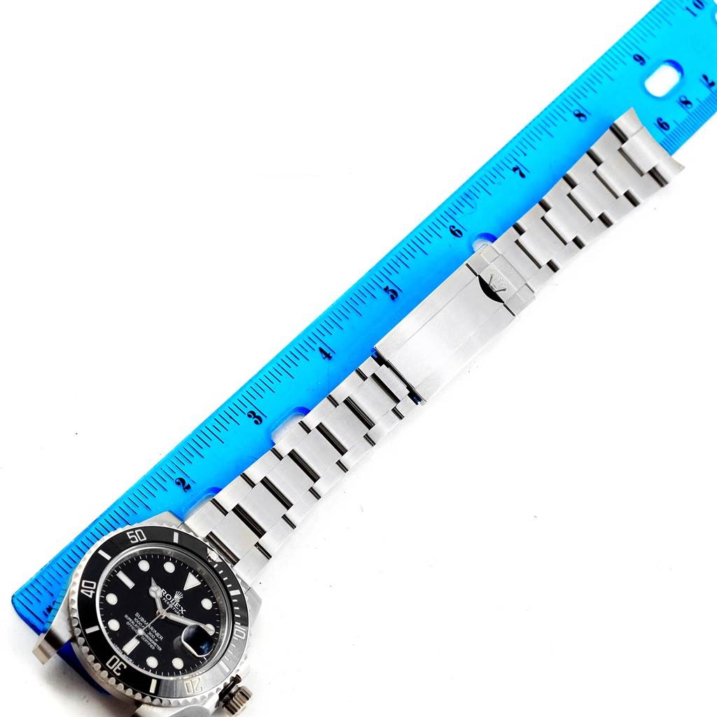 The image shows the Rolex Submariner 116610 Men's Stainless Steel Black Dial 116610 Men's Stainless Steel Black Dial watch laid flat with a blue ruler measuring its bracelet length.