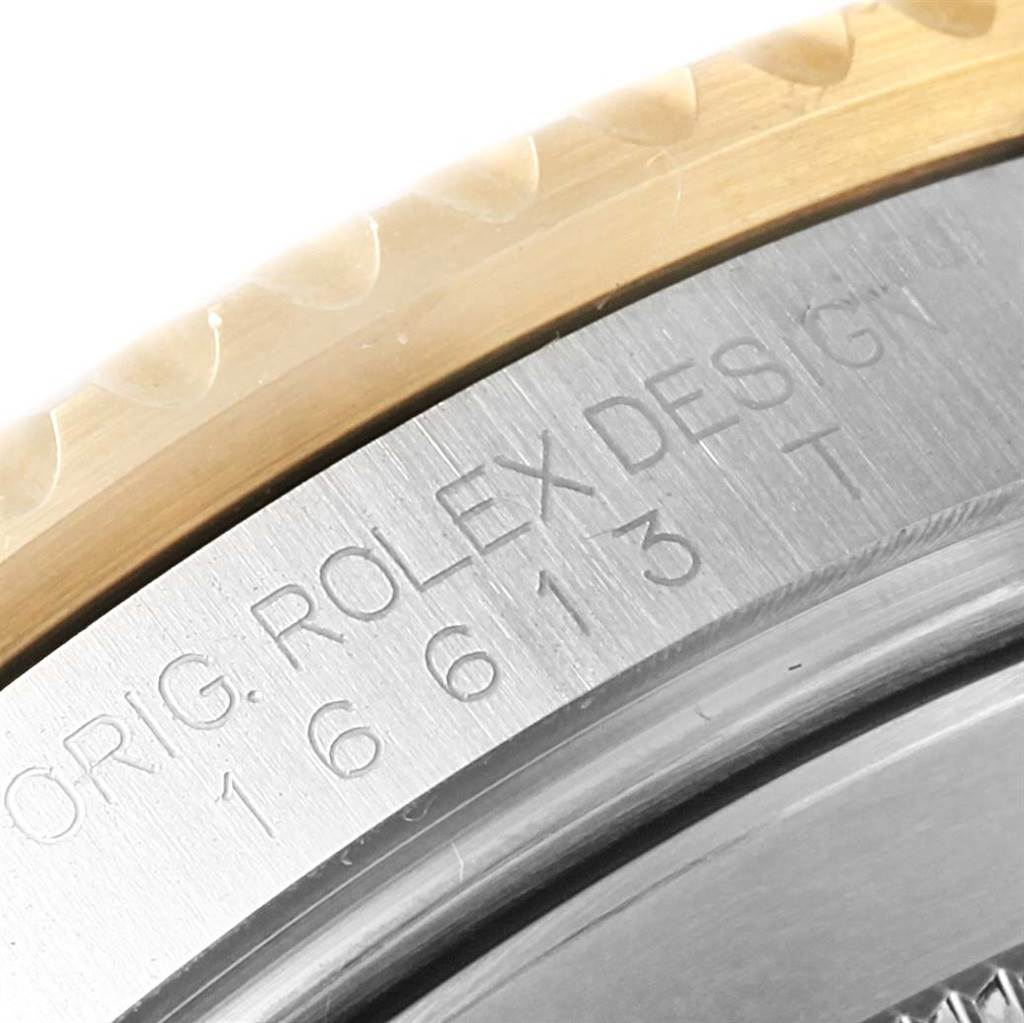 The close-up image shows the etched side of the case and bezel of a Rolex Submariner 16613 Men
s Steel and Gold (two tone) Black Dial 16613 Men
s Steel and Gold (two tone) Black Dial model.