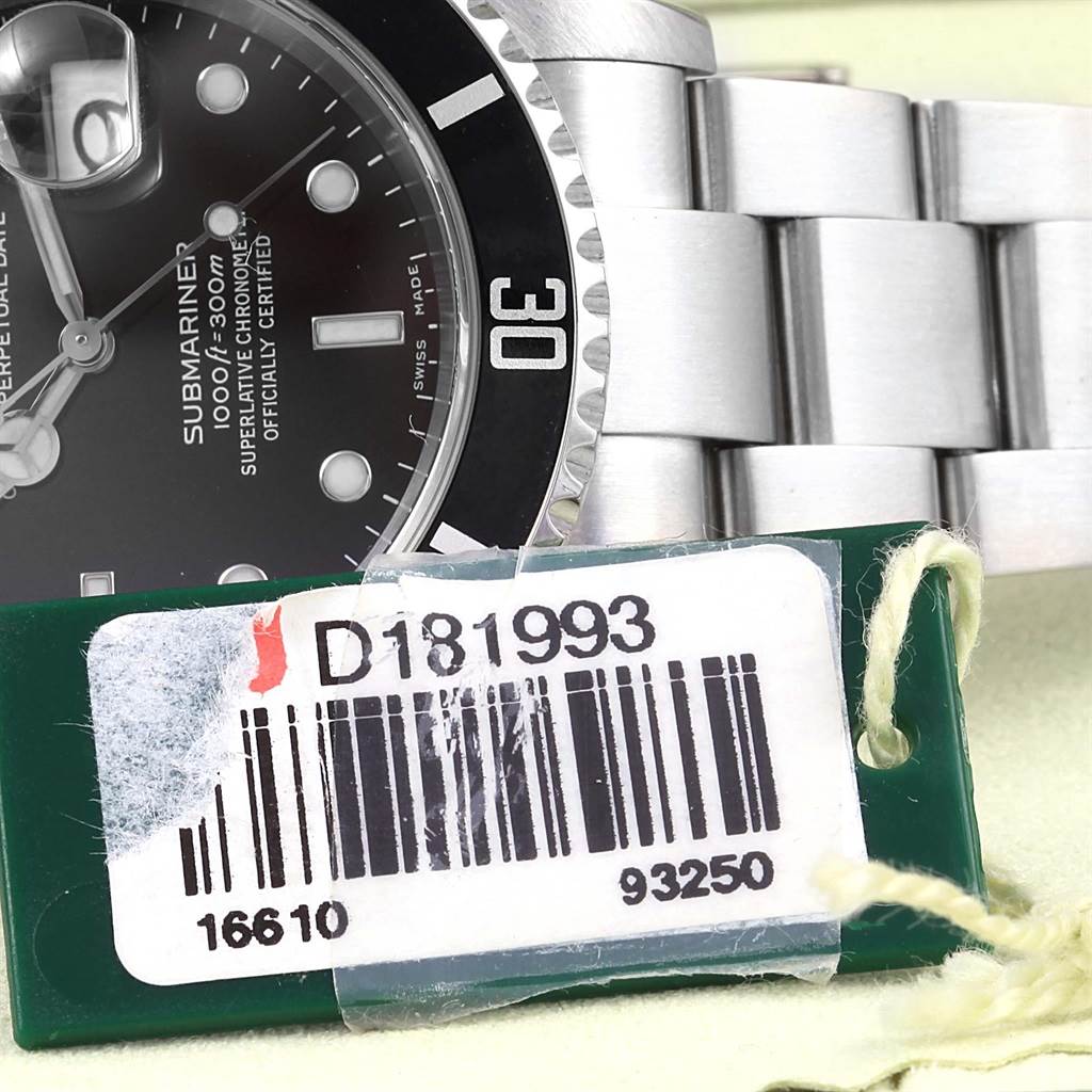 The image shows a close-up of the watch face and part of the bracelet of a Rolex Submariner 16610 Men's Stainless Steel Black Dial 16610 Men's Stainless Steel Black Dial model, with a barcode tag in the foreground.