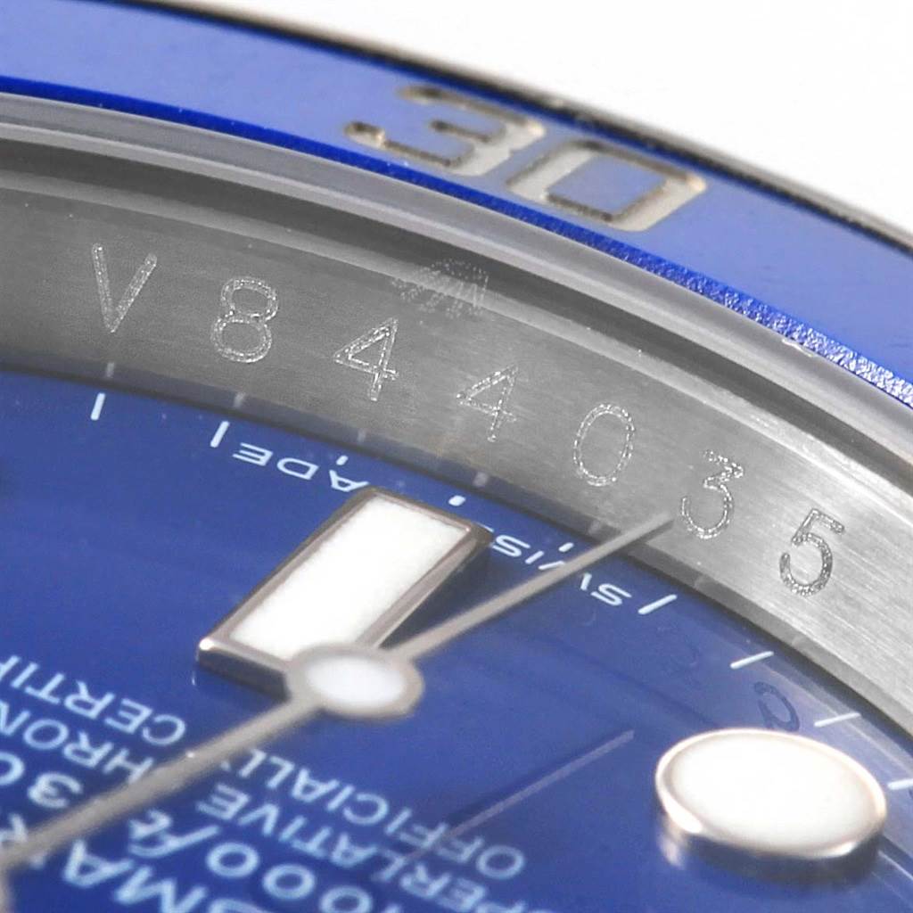 This close-up angle of the Rolex Submariner 116619 Men's White Gold Blue Dial 116619 Men's White Gold Blue Dial watch shows part of the bezel, dial, and serial number engraving.