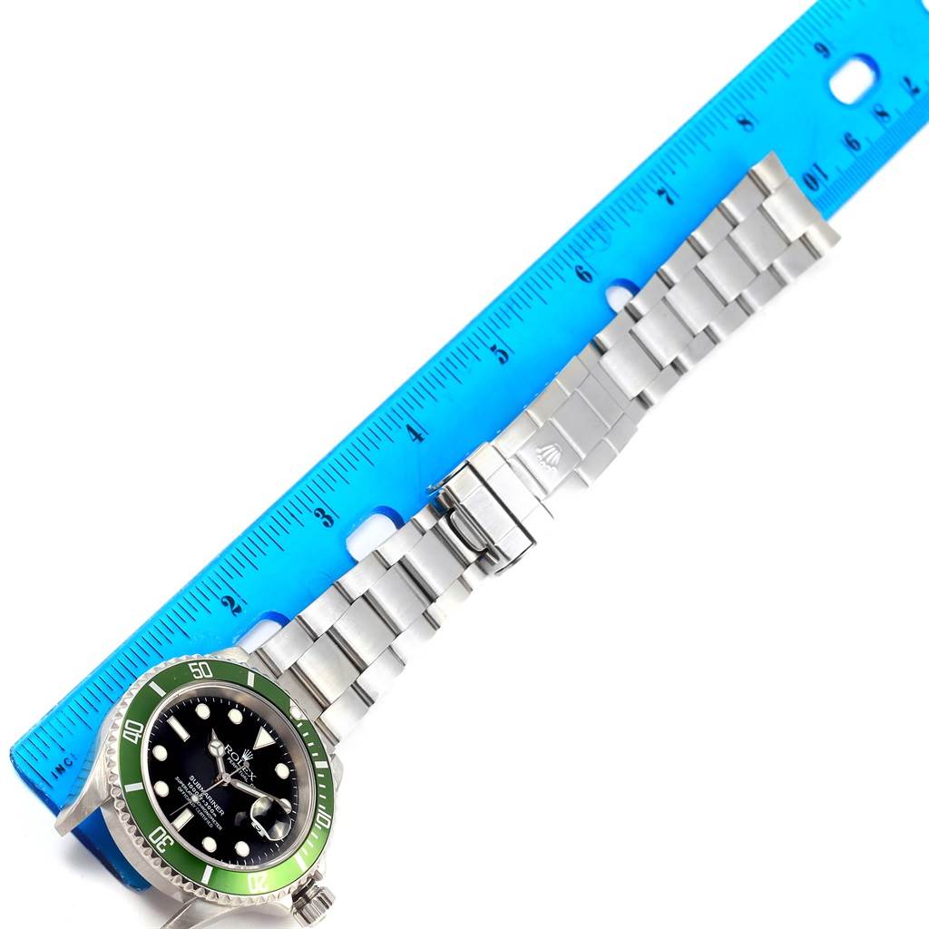 The image shows a Rolex Submariner 16610LV Men's Stainless Steel Black Dial 16610LV Men's Stainless Steel Black Dial watch, showcasing the face, bezel, and full bracelet alongside a ruler for measurement.