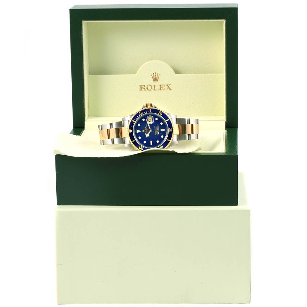 The Rolex Submariner 16613 Men's Steel and Gold (two tone) Blue Dial 16613 Men's Steel and Gold (two tone) Blue Dial watch is shown head-on in its box, displaying the face, bezel, and bracelet.