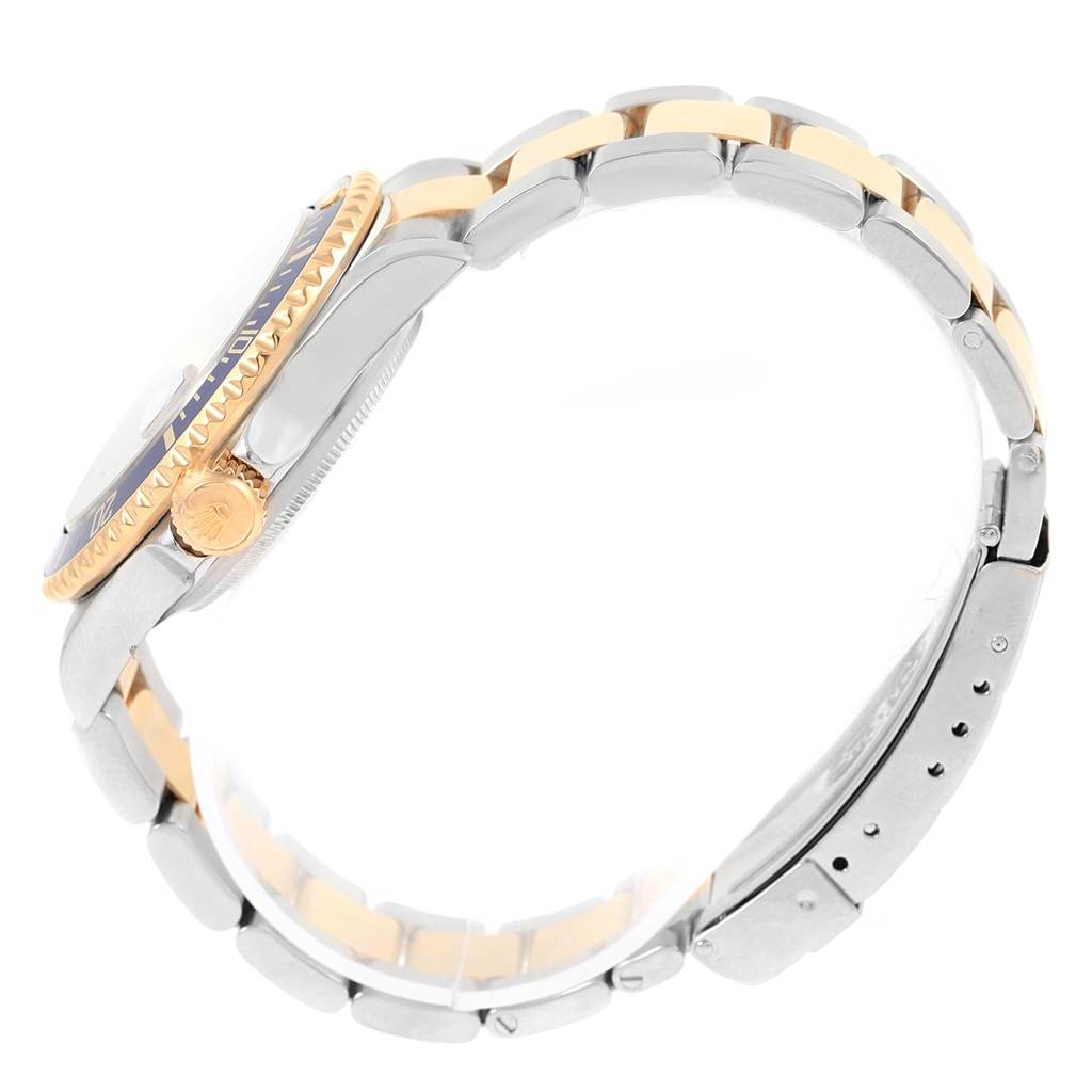 The image shows a side view of a Rolex Submariner 16613 Men's Steel and Gold (two tone) Blue Dial 16613 Men's Steel and Gold (two tone) Blue Dial watch, highlighting its gold and silver two-tone bracelet and the crown.