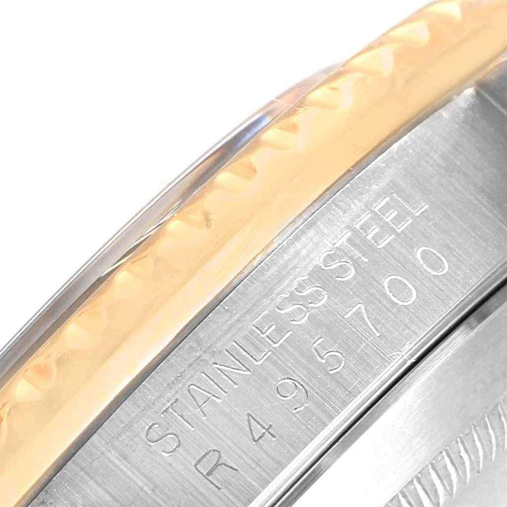 The image is a close-up of the side of a Rolex Submariner 16803 Men's Steel and Gold (two tone) Black Dial 16803 Men's Steel and Gold (two tone) Black Dial watch, showing the edge of the bezel and part of the stainless steel case with engravings.