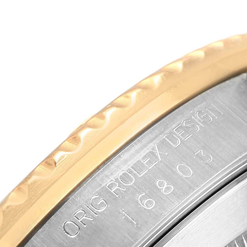 This image shows a close-up of the case back of the Rolex Submariner 16803 Men's Steel and Gold (two tone) Black Dial 16803 Men's Steel and Gold (two tone) Black Dial, featuring engraved design details and model number "16803".