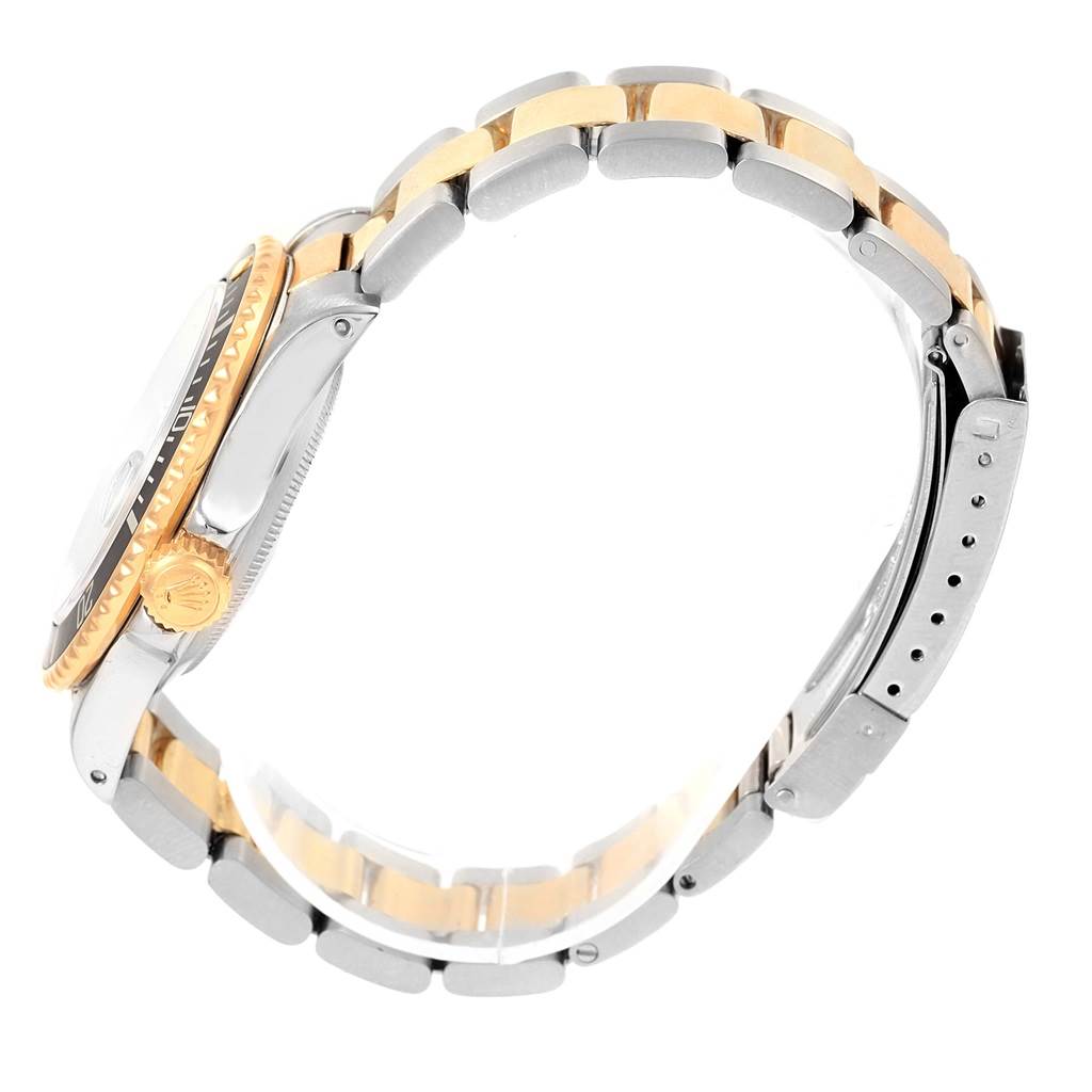 This image shows a Rolex Submariner 16803 Men's Steel and Gold (two tone) Black Dial 16803 Men's Steel and Gold (two tone) Black Dial watch from a side angle, highlighting its bezel, crown, and two-tone bracelet.