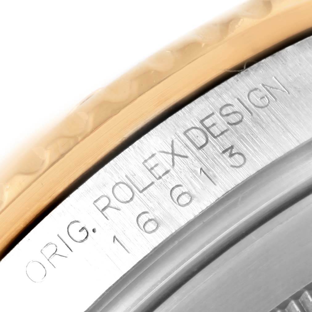 This close-up angle shows the engraved model number and "Rolex Design" on a Rolex Submariner 16613 Men's Steel and Gold (two tone) Champagne Dial 16613 Men's Steel and Gold (two tone) Champagne Dial's case.
