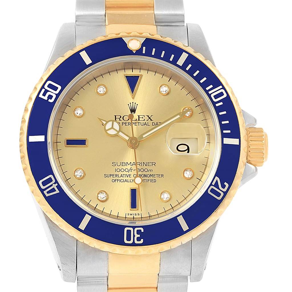 The image shows a front view of a Rolex Submariner 16613 Men's Steel and Gold (two tone) Champagne Dial 16613 Men's Steel and Gold (two tone) Champagne Dial watch, highlighting its gold dial, blue bezel, and two-tone bracelet.