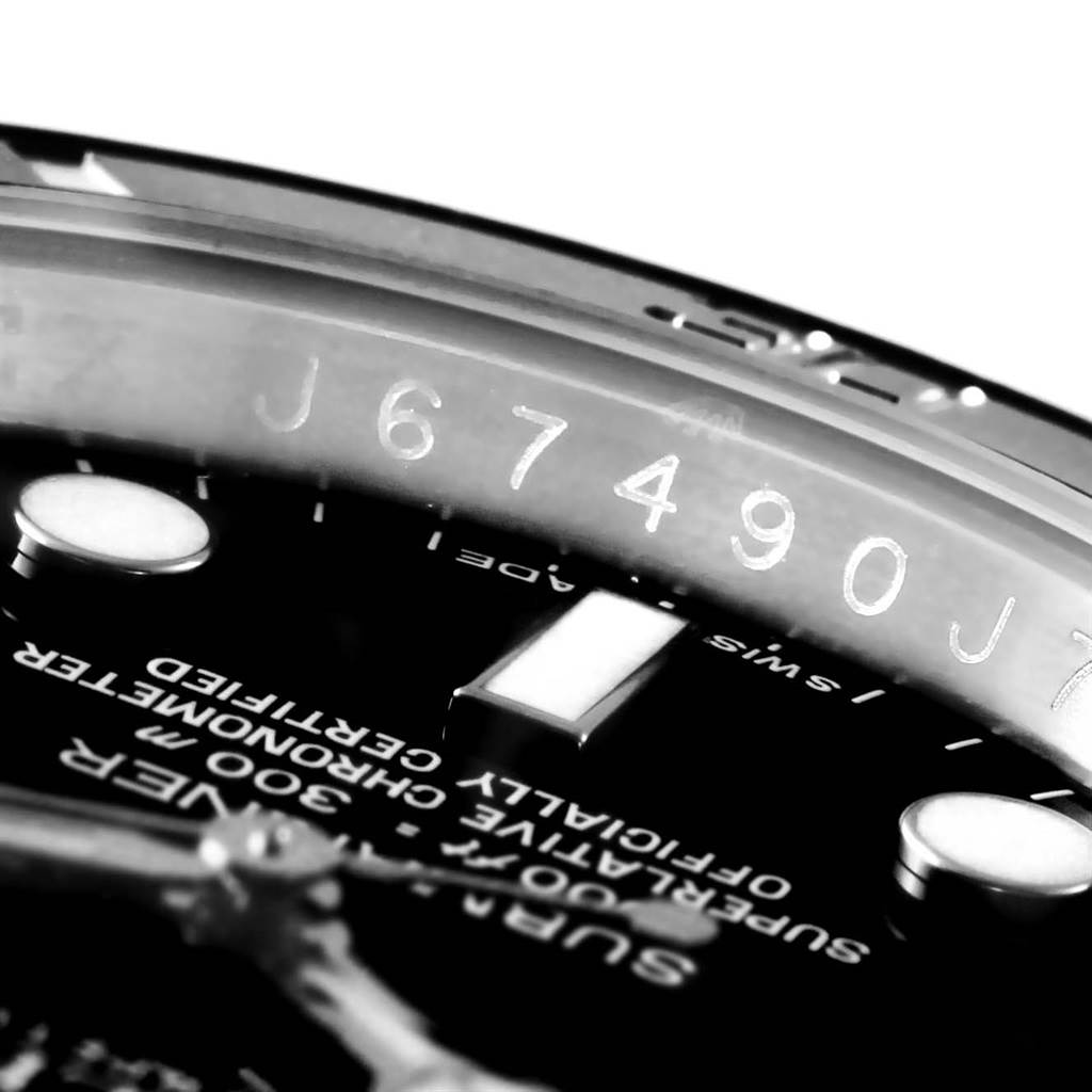 Close-up angle of the Rolex Submariner 116610 Men's Stainless Steel Black Dial 116610 Men's Stainless Steel Black Dial, showcasing part of the dial, a luminescent marker, and the engraved serial number on the inner bezel.
