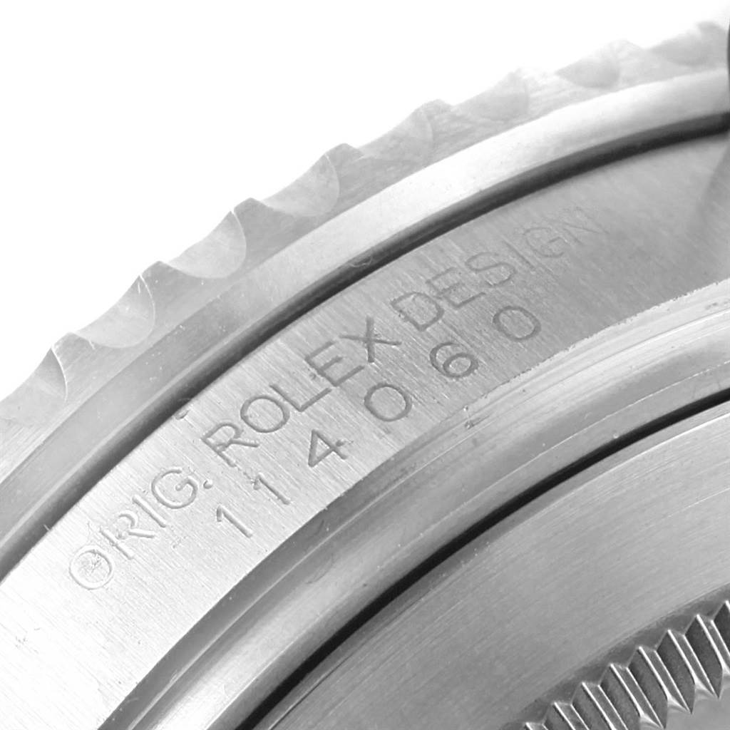 This image shows a close-up of the bezel and the engraved serial number on the case back of a Rolex Submariner 114060 Men's Stainless Steel Black Dial 114060 Men's Stainless Steel Black Dial watch.