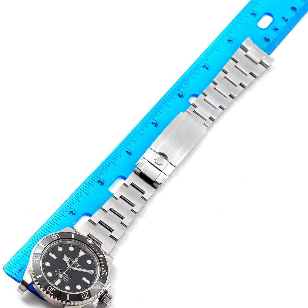 The image shows a Rolex Submariner 114060 Men's Stainless Steel Black Dial 114060 Men's Stainless Steel Black Dial watch laid flat, with its bracelet extended and measured against a blue ruler.