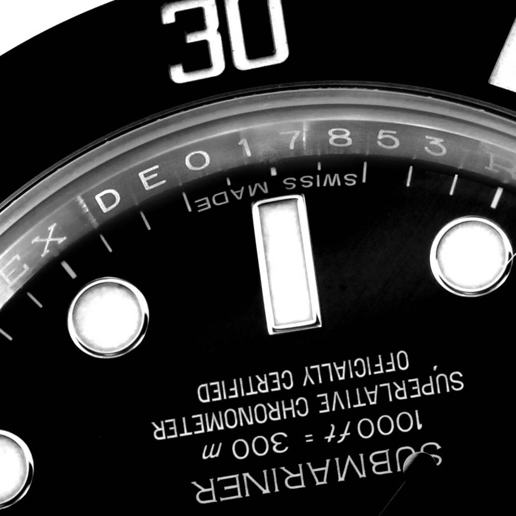 This image shows a close-up of the dial on a Rolex Submariner 114060 Men's Stainless Steel Black Dial 114060 Men's Stainless Steel Black Dial watch displaying part of the bezel, indices, and text.