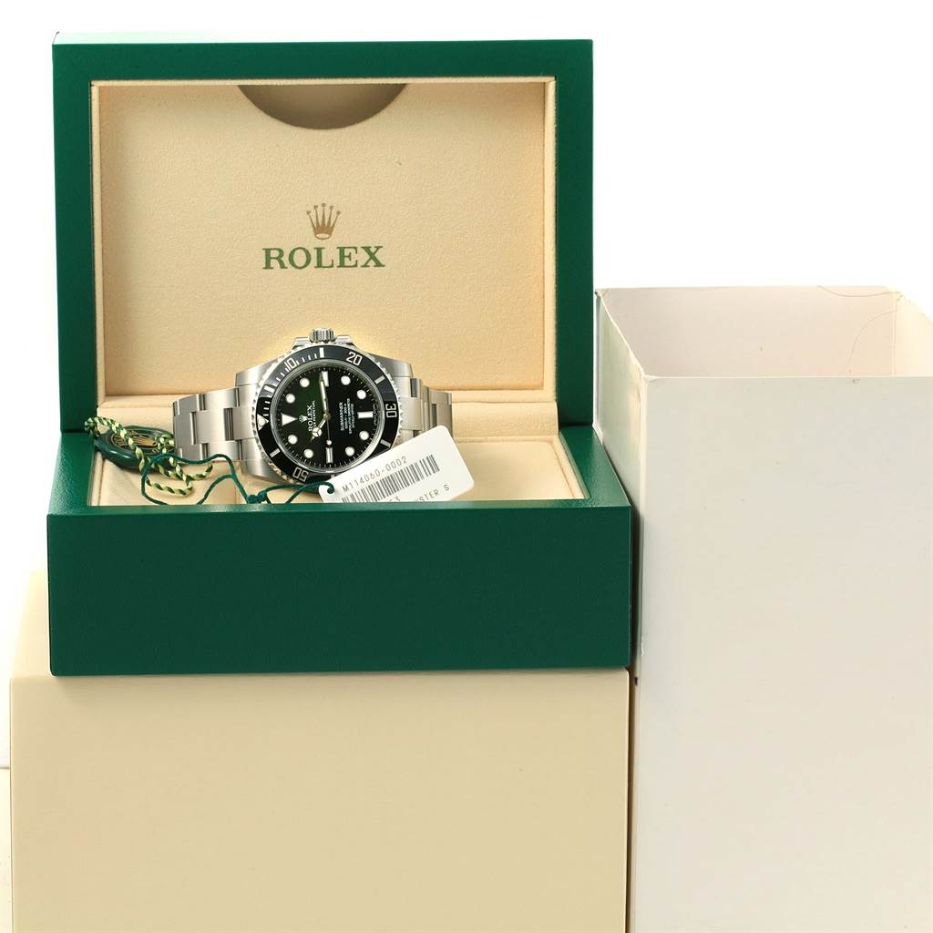 The Rolex Submariner 114060 Men's Stainless Steel Black Dial 114060 Men's Stainless Steel Black Dial watch is displayed frontally in its open green box with branding visible inside.
