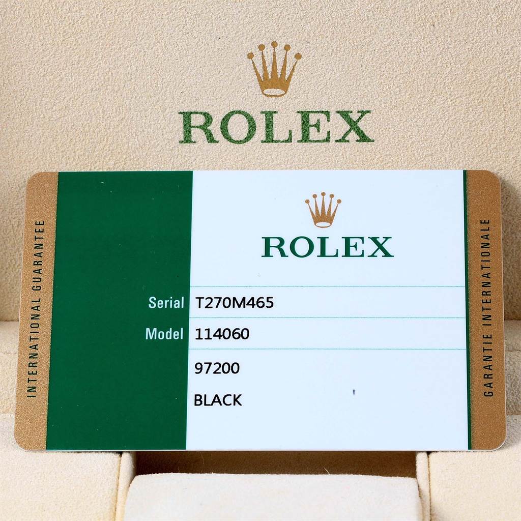 The image shows a close-up of a Rolex guarantee card for a Submariner model 114060.
