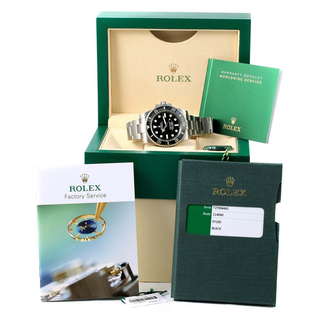 The image shows a Rolex Submariner 114060 Men's Stainless Steel Black Dial 114060 Men's Stainless Steel Black Dial watch along with its box, warranty booklet, factory service booklet, and identification tag.