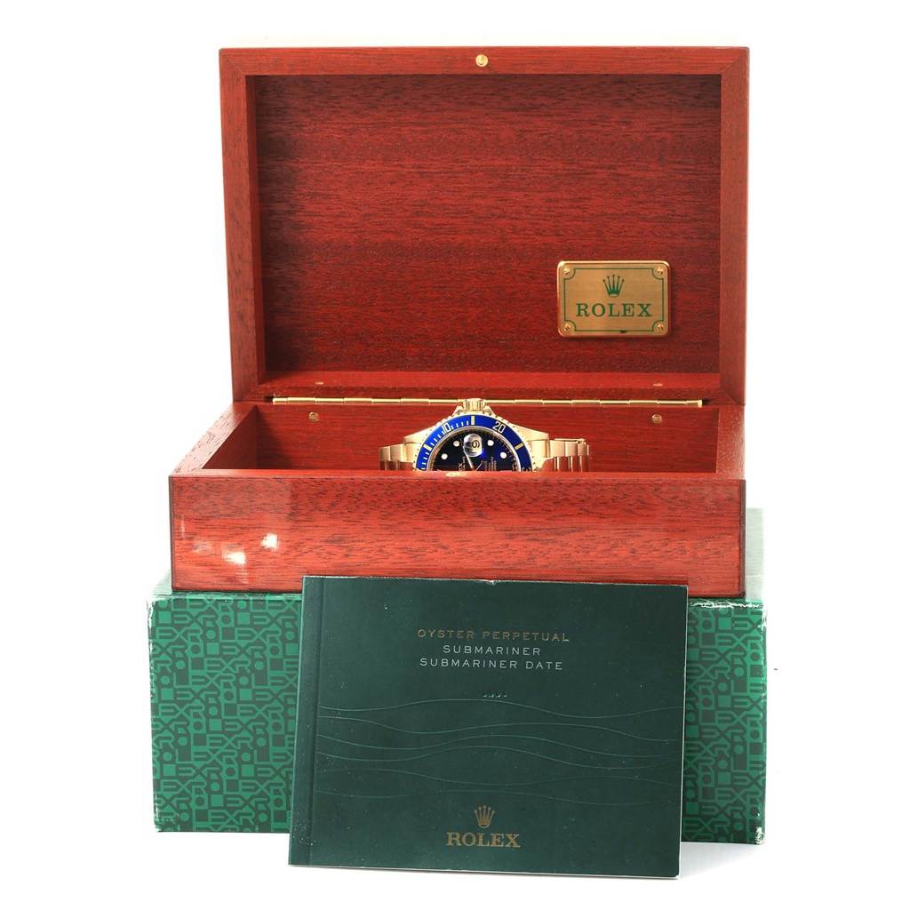 The image shows a Rolex Submariner 16618 Men's Yellow Gold Blue Dial 16618 Men's Yellow Gold Blue Dial watch inside its wooden box with the instruction manual in front.