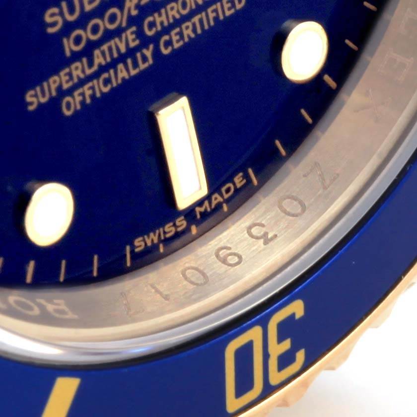 This close-up angle shows the blue dial, markers, and part of the bezel of a Rolex Submariner 16618 Men's Yellow Gold Blue Dial 16618 Men's Yellow Gold Blue Dial.