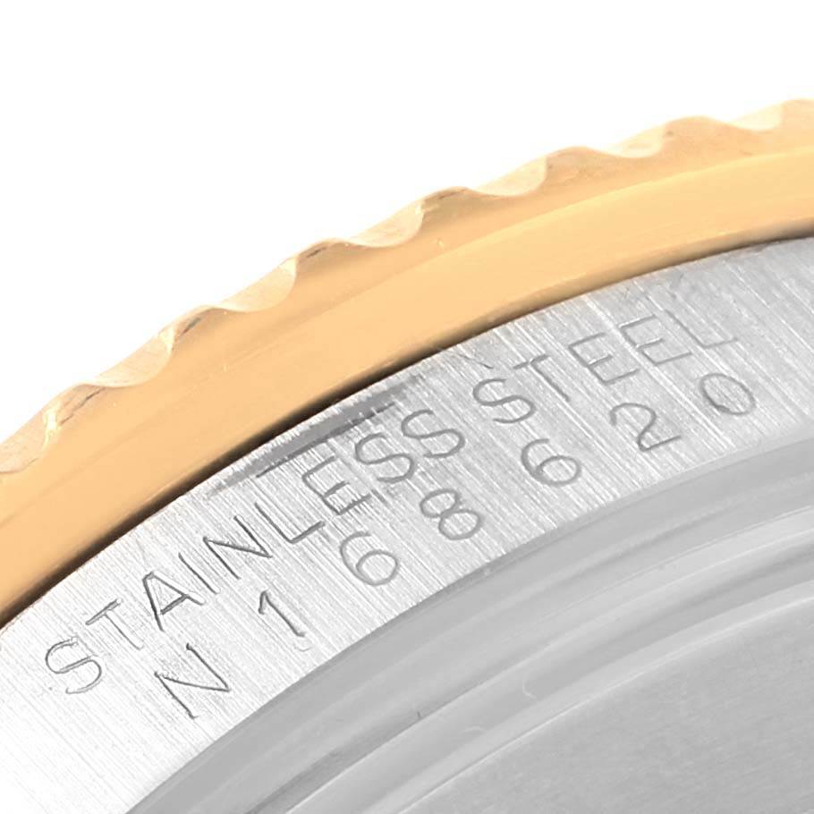 This image shows a close-up of the engraved side detail of the bezel and case of a Rolex Submariner 16613 Men
s Steel and Gold (two tone) Purple Dial 16613 Men
s Steel and Gold (two tone) Purple Dial.