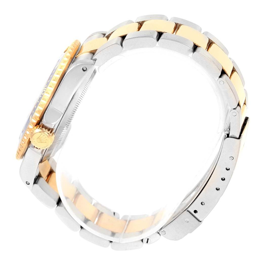 The Rolex Submariner 16613 Men's Steel and Gold (two tone) Blue Dial 16613 Men's Steel and Gold (two tone) Blue Dial watch is shown from a side angle, highlighting its bracelet, crown, bezel, and clasp.