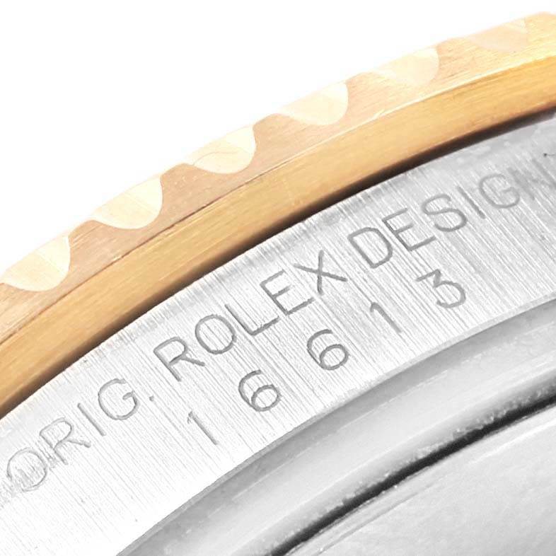 The image shows a close-up angle of the bezel and side engraving of a Rolex Submariner 16613 Men's Steel and Gold (two tone) Blue Dial 16613 Men's Steel and Gold (two tone) Blue Dial watch.