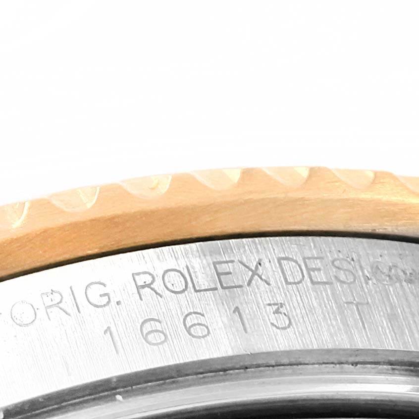 The image shows a close-up of the bezel and part of the casing with etched markings of the Rolex Submariner 16613 Men's Steel and Gold (two tone) Blue Dial 16613 Men's Steel and Gold (two tone) Blue Dial model.