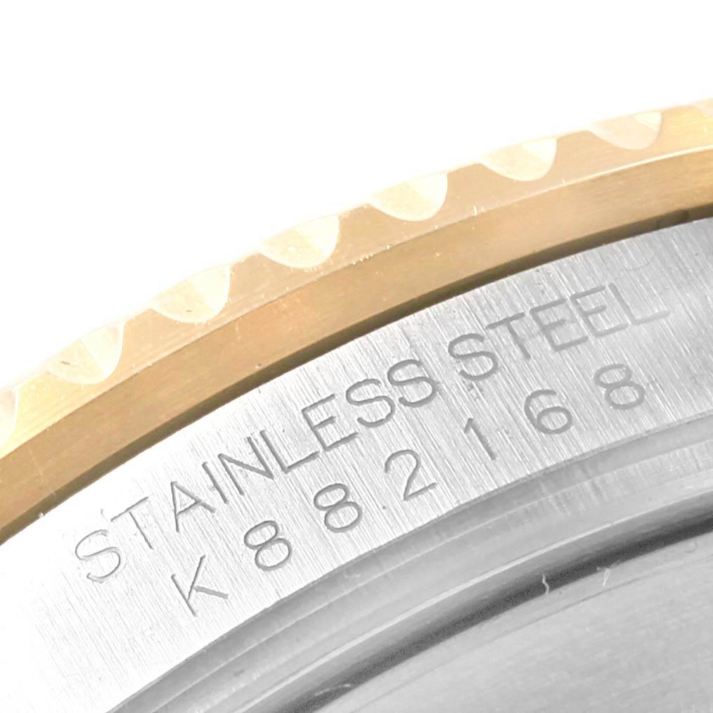 This image shows a close-up of the engraved back case and bezel edge of a Submariner model by Rolex.