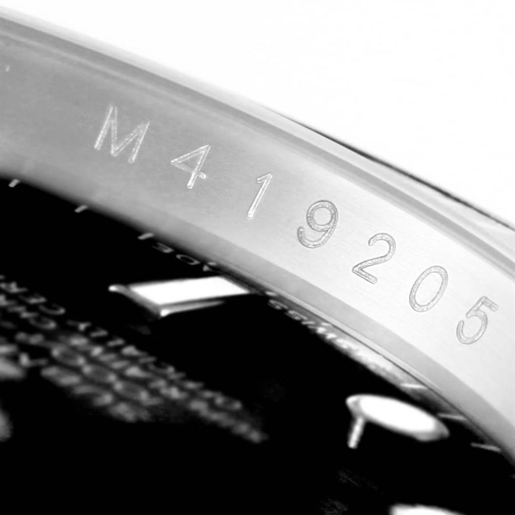 This macro shot of the Rolex Submariner 16610 Men's Stainless Steel Black Dial 16610 Men's Stainless Steel Black Dial shows the serial number engraved on the inner bezel.
