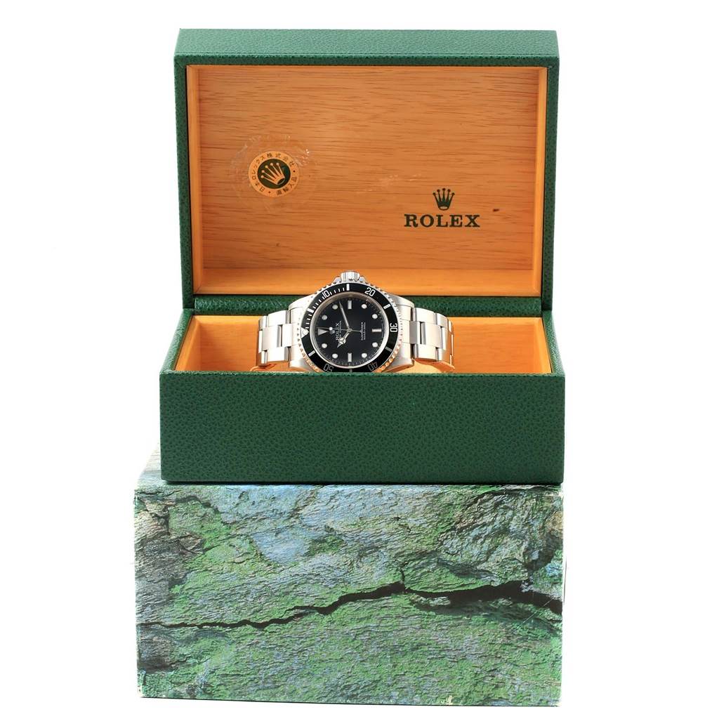 The image shows a Rolex Submariner 14060 Men's Stainless Steel Black Dial 14060 Men's Stainless Steel Black Dial watch displayed front-on inside its open green and wooden box.