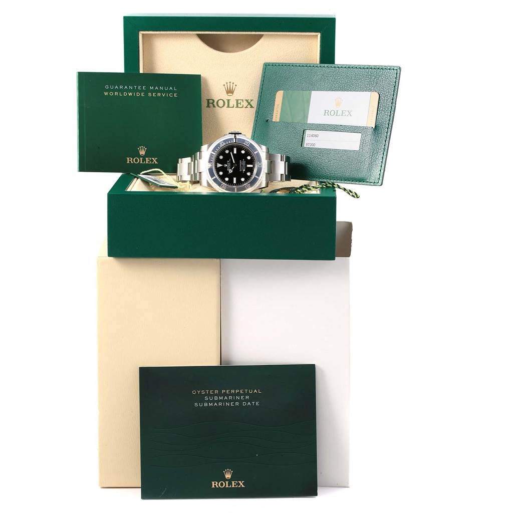 The image shows a frontal view of a Rolex Submariner 114060 Men's Stainless Steel Black Dial 114060 Men's Stainless Steel Black Dial watch with its box, manuals, and warranty card.
