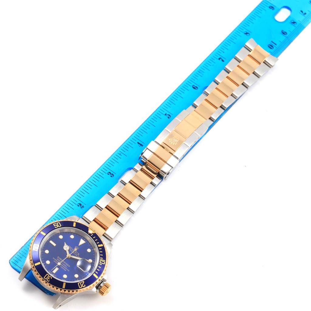 The Rolex Submariner 16613 Men's Steel and Gold (two tone) Blue Dial 16613 Men's Steel and Gold (two tone) Blue Dial watch is shown from a top view, highlighting the face, bezel, bracelet, and clasp.